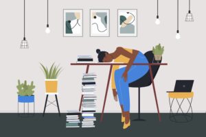 An illustration of a woman with her head on a table, eyes closed. There is a large stack of books nearby.
